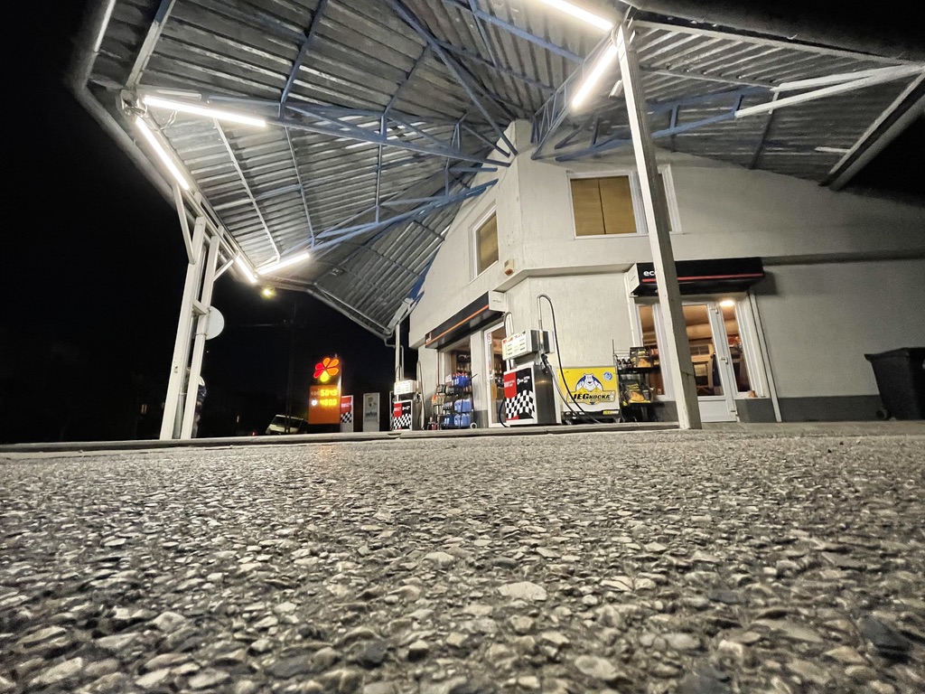 barber using styling spray on young man with black hair, short on sides and long in a quiff on top